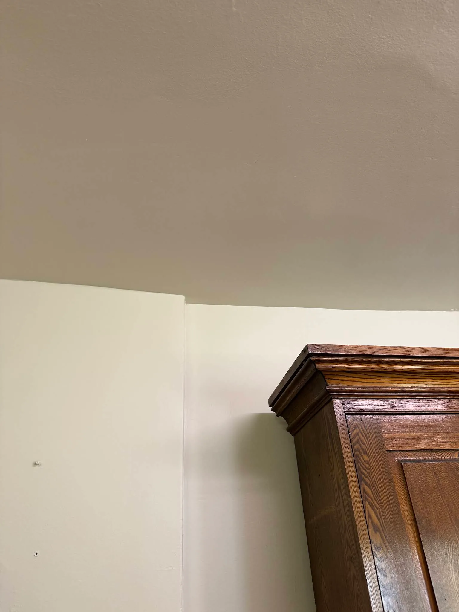 Clean ceiling and wall transition beside dark kitchen cabinetry