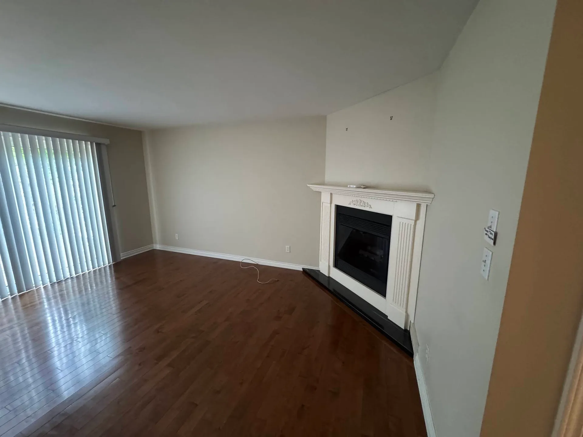 Empty living room finished with light walls and a white fireplace