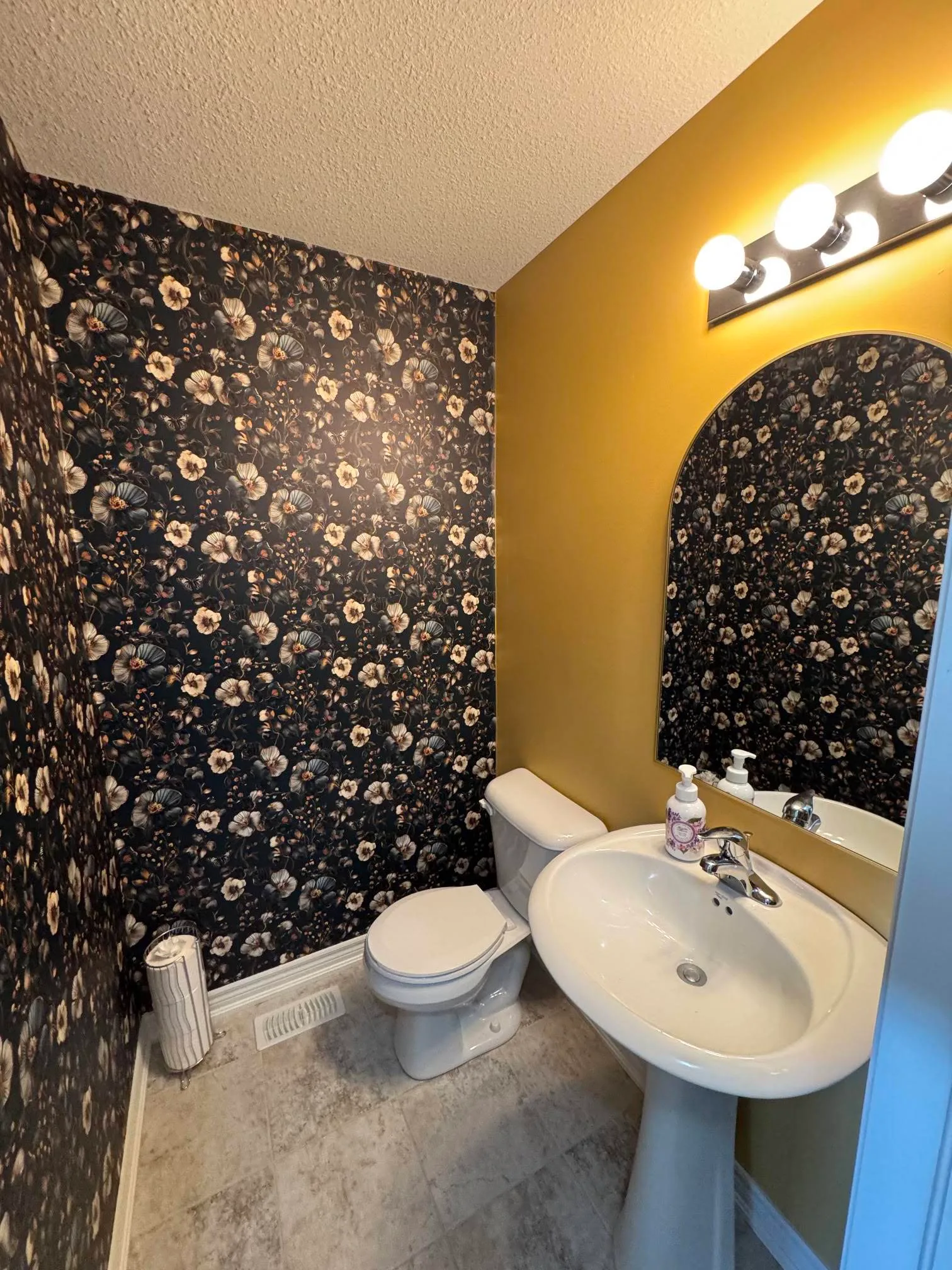 Powder room with patterned feature wall and warm accent colour